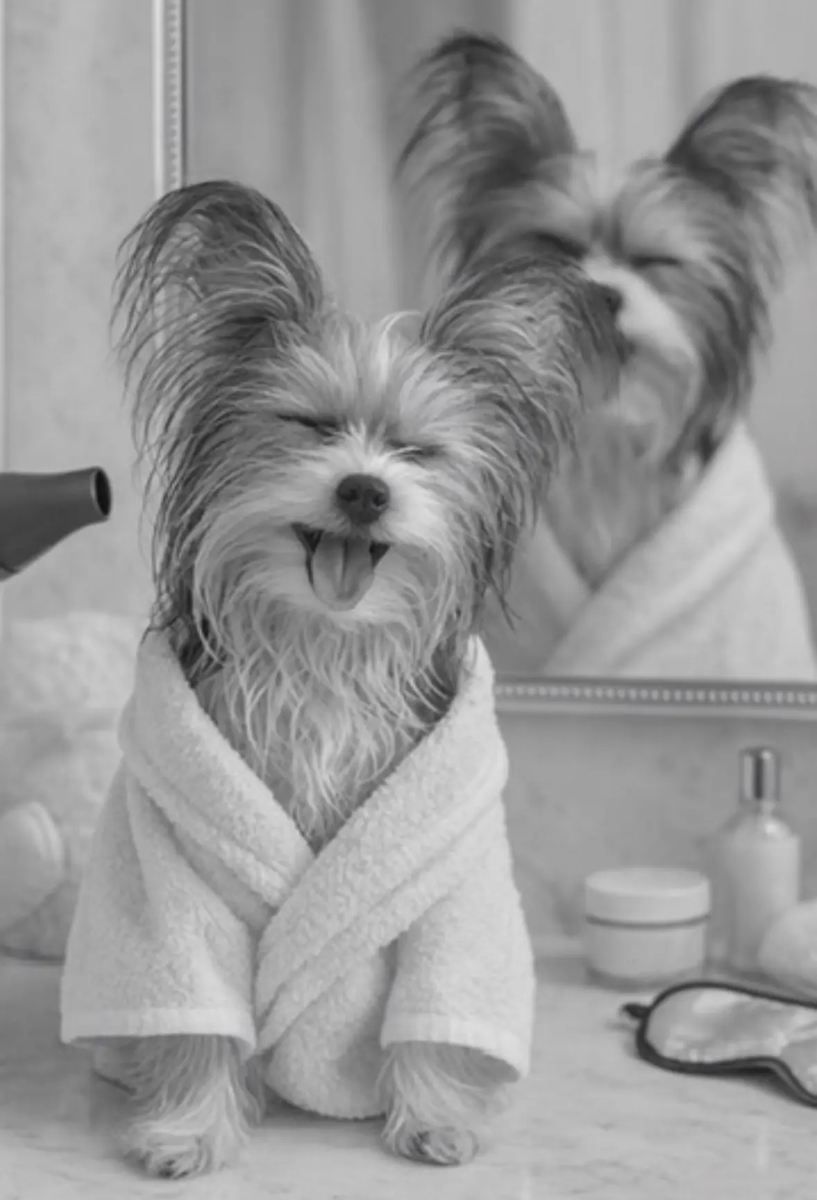 Black-and-white portrait of Belle smiling in a spa robe in front of a mirror