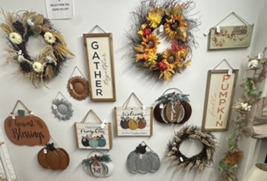 Assortment of fall wreaths, pumpkin signs and seasonal wall decorations