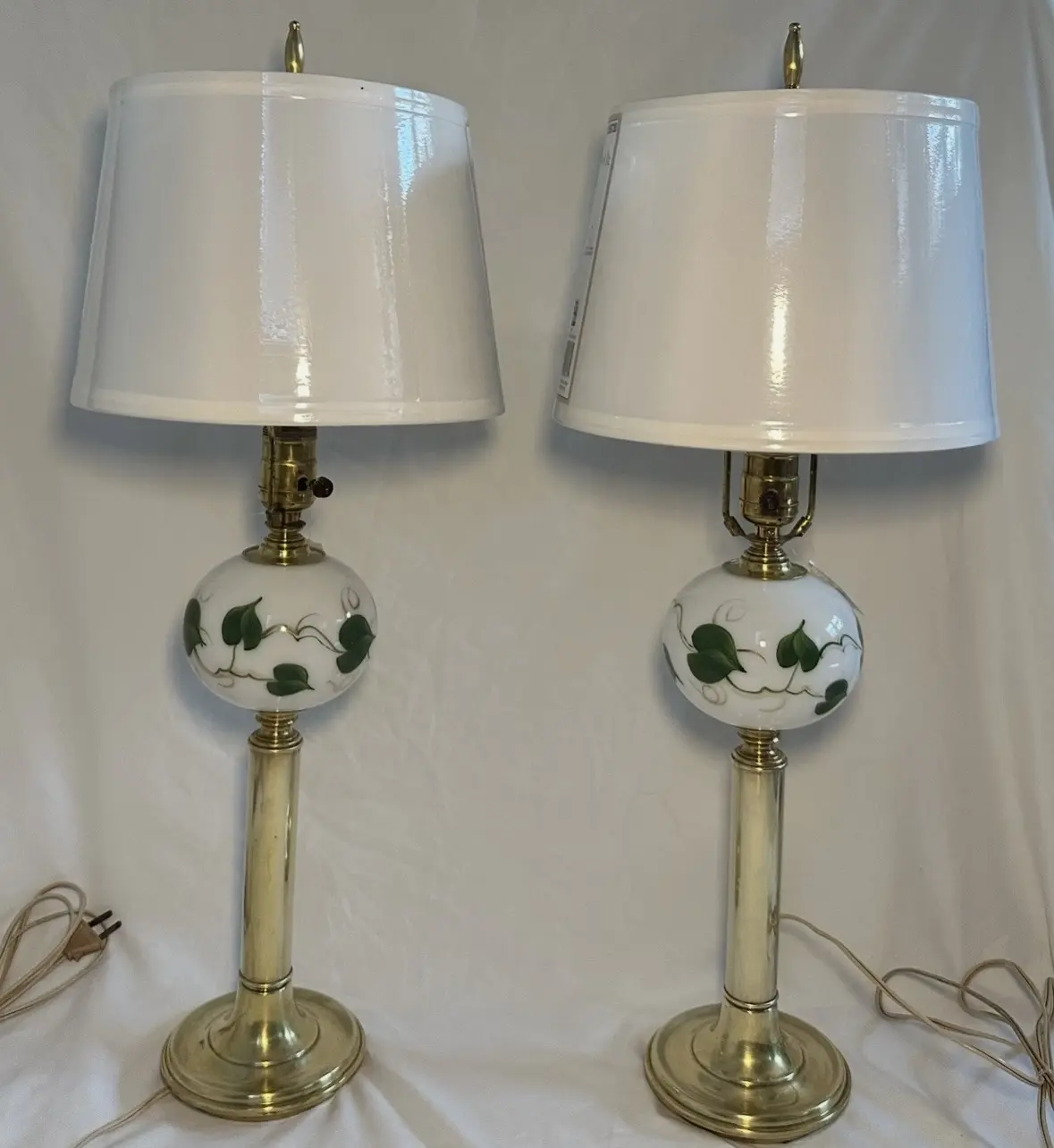 Matching brass and white floral lamps with green vine motifs and white shades