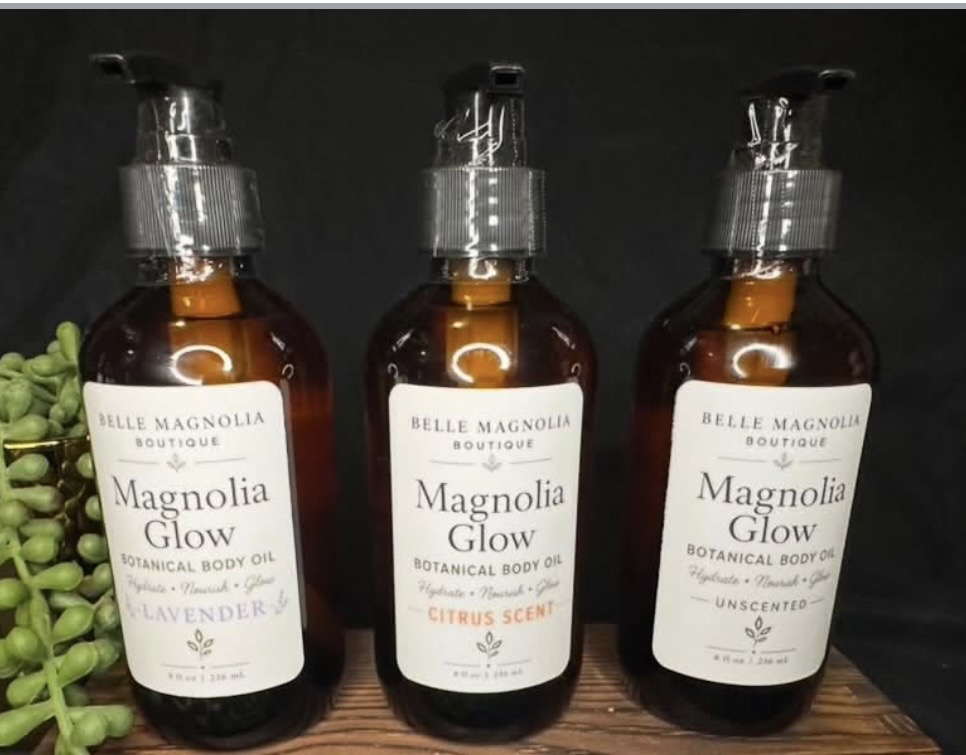 Three Magnolia Glow Botanical Body Oil bottles in lavender, citrus and unscented varieties