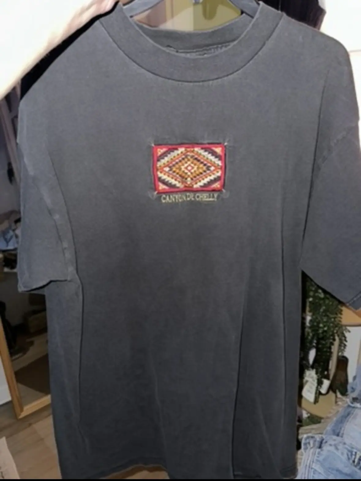 Charcoal gray tee with a colorful embroidered geometric chest motif